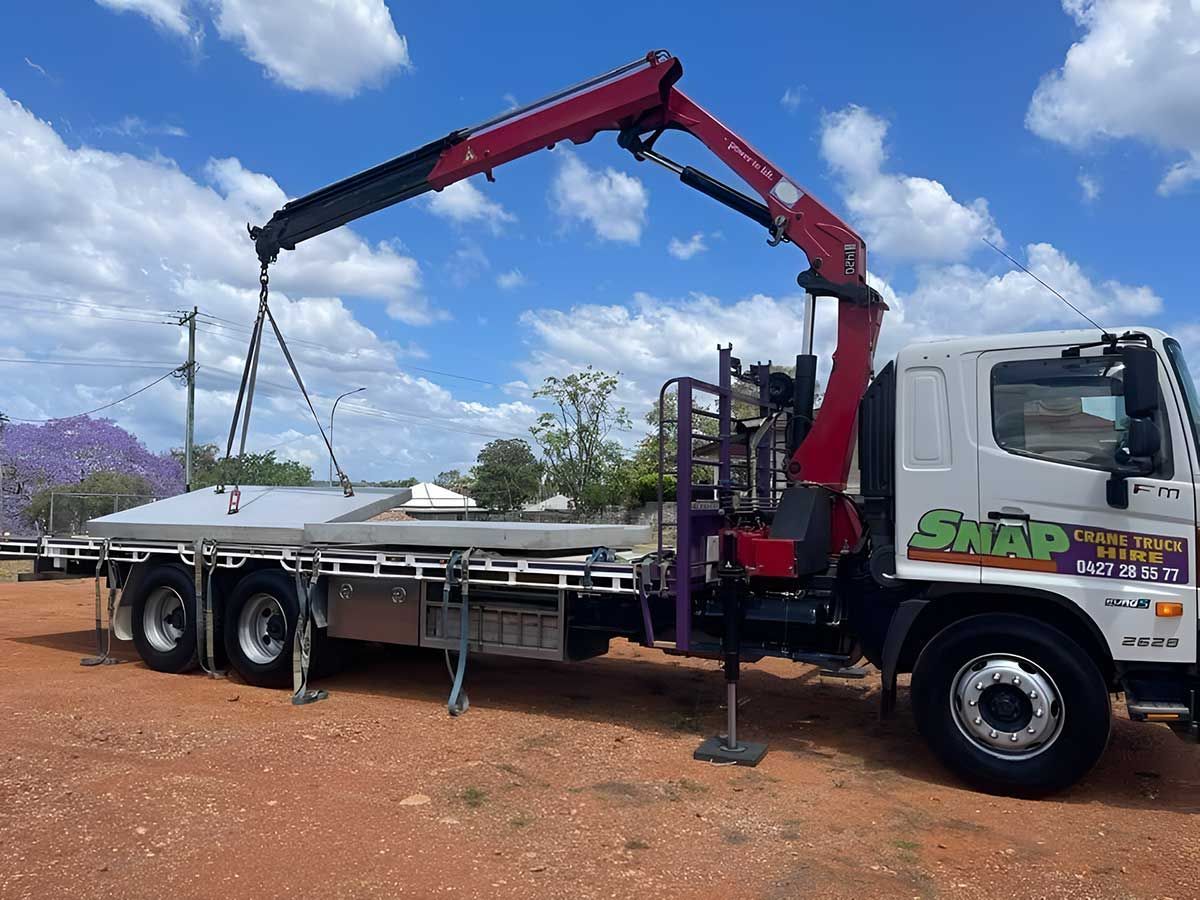A Truck With A Crane Attached To It Is Parked In A Dirt Field — Snap Crane Truck Hire in South Kempsey, NSW