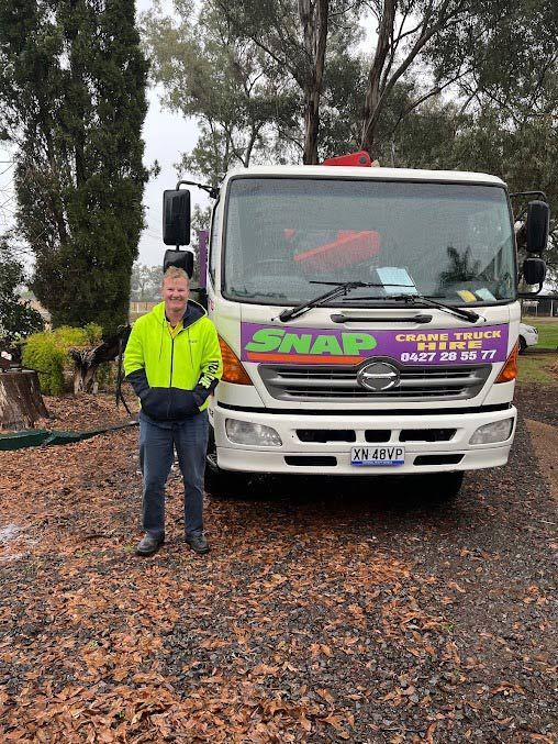 A Man Is Standing In Front Of A Truck — Snap Crane Truck Hire in Tamworth, NSW