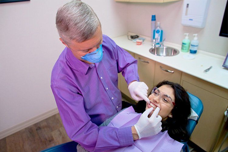 dentist examining patient's teeth, westend dental associates