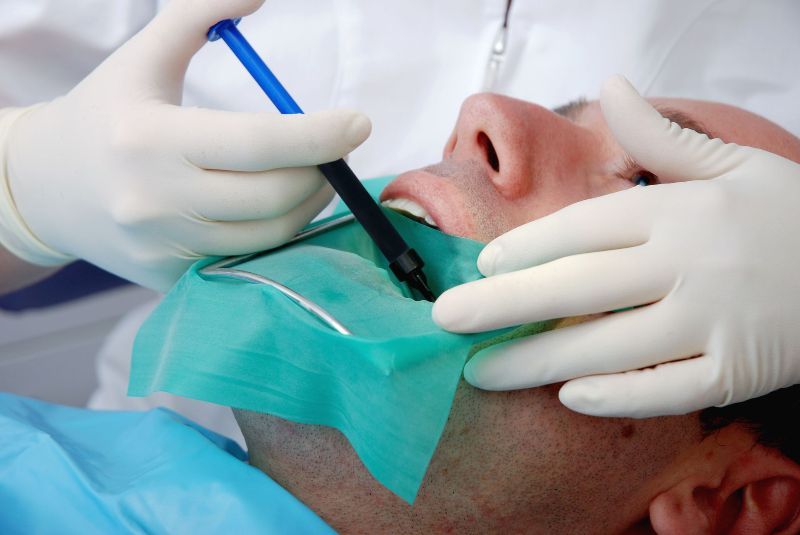 A man is getting his teeth examined by a dentist