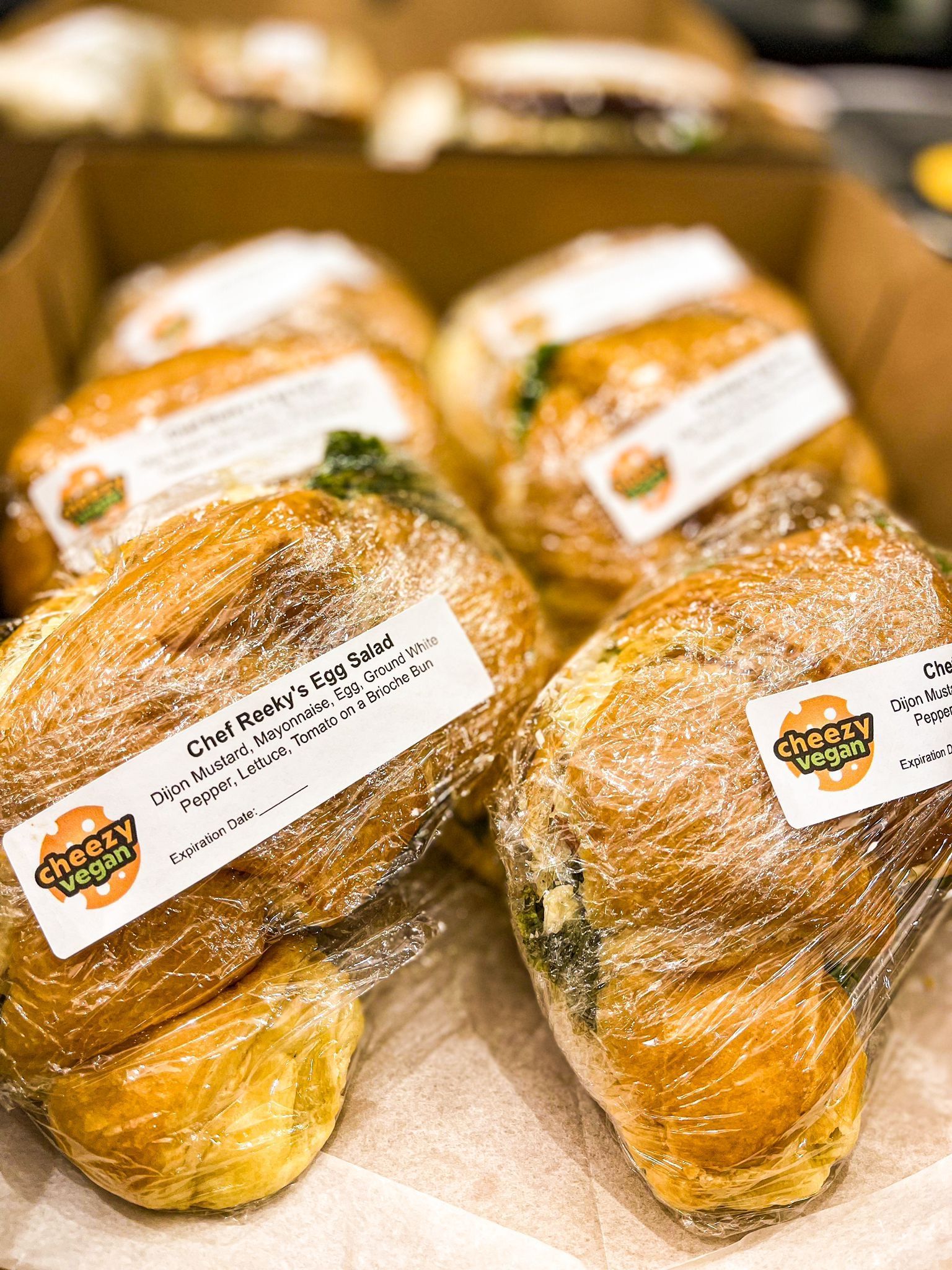 Several golden-brown bread rolls wrapped in plastic, labeled with