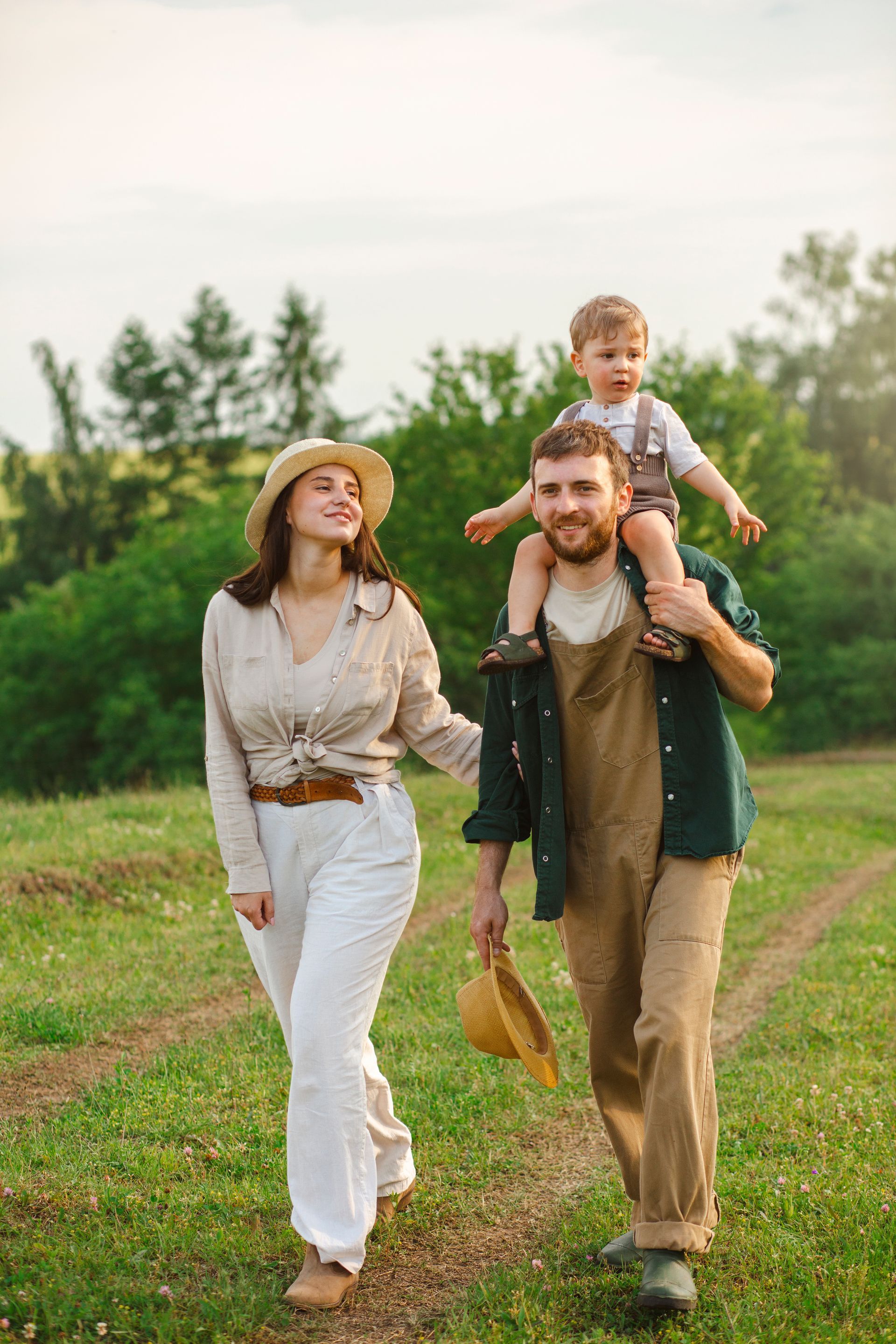 Person writing in a notebook at a table with a laptop and another person using a phone.