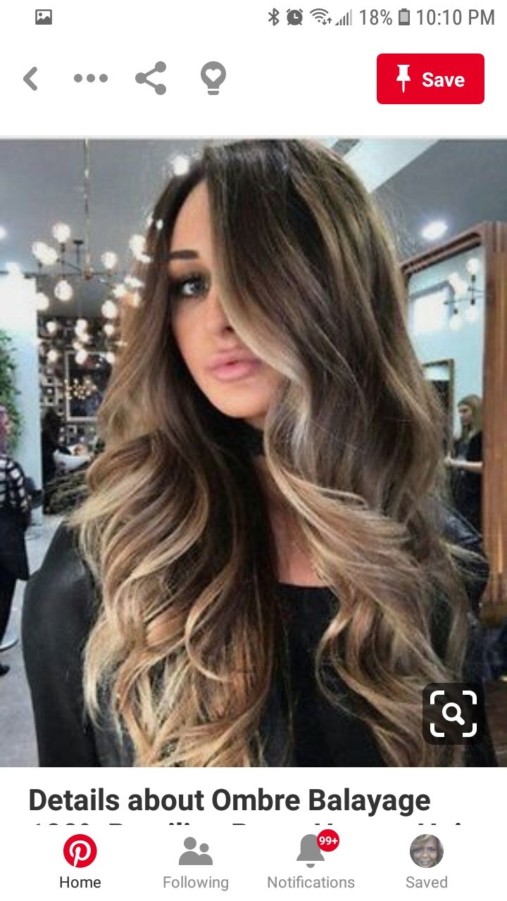 Long wavy brown hair with blonde ombré highlights in a salon-style photo