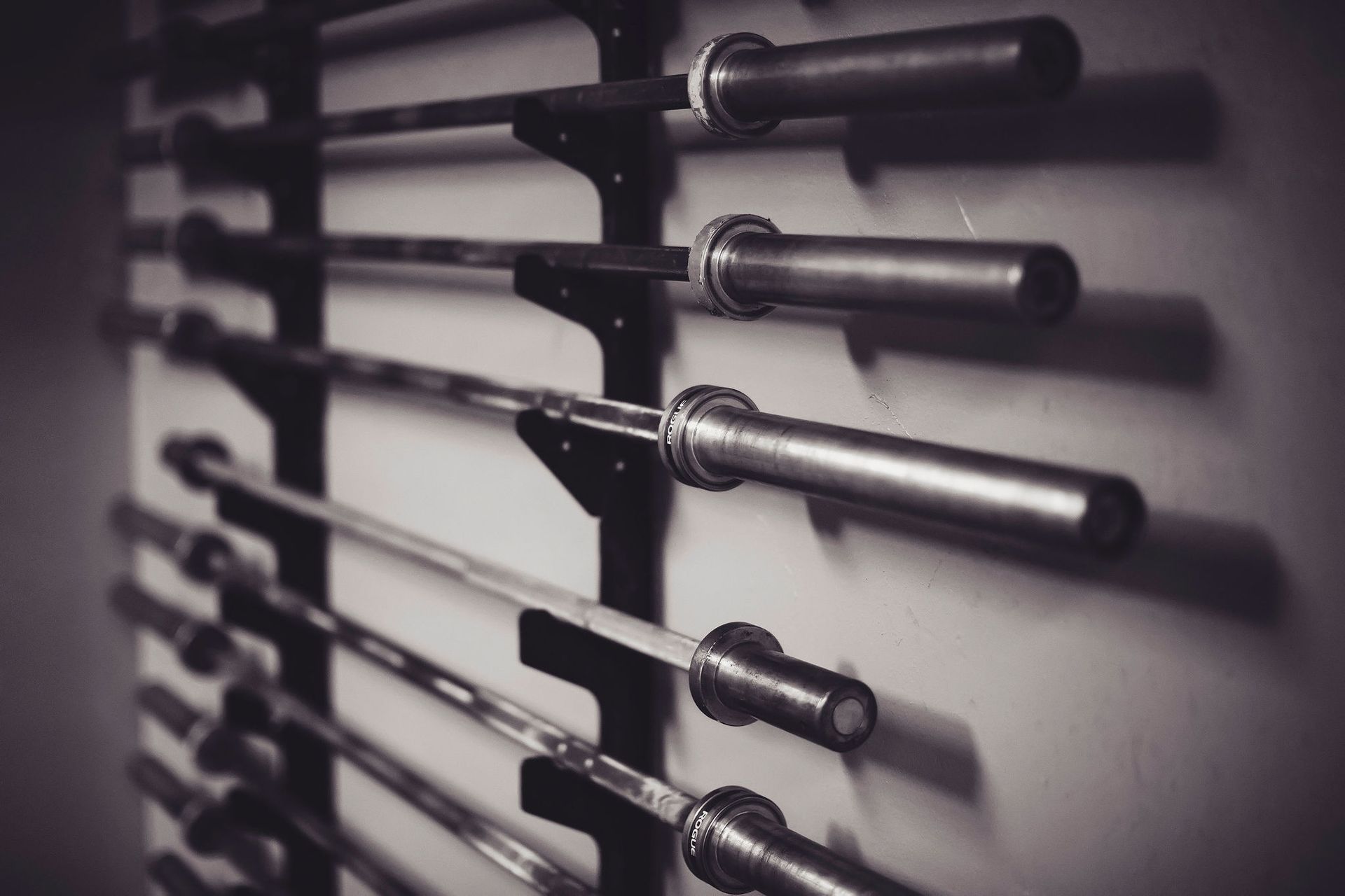 A row of barbells hanging on a wall in a gym.