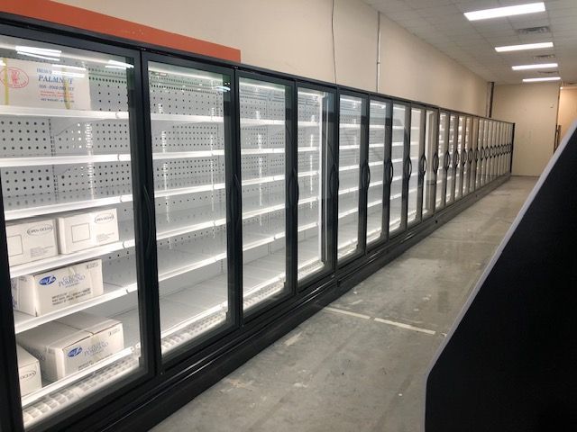 A grocery store refrigerator filled with lots of food.