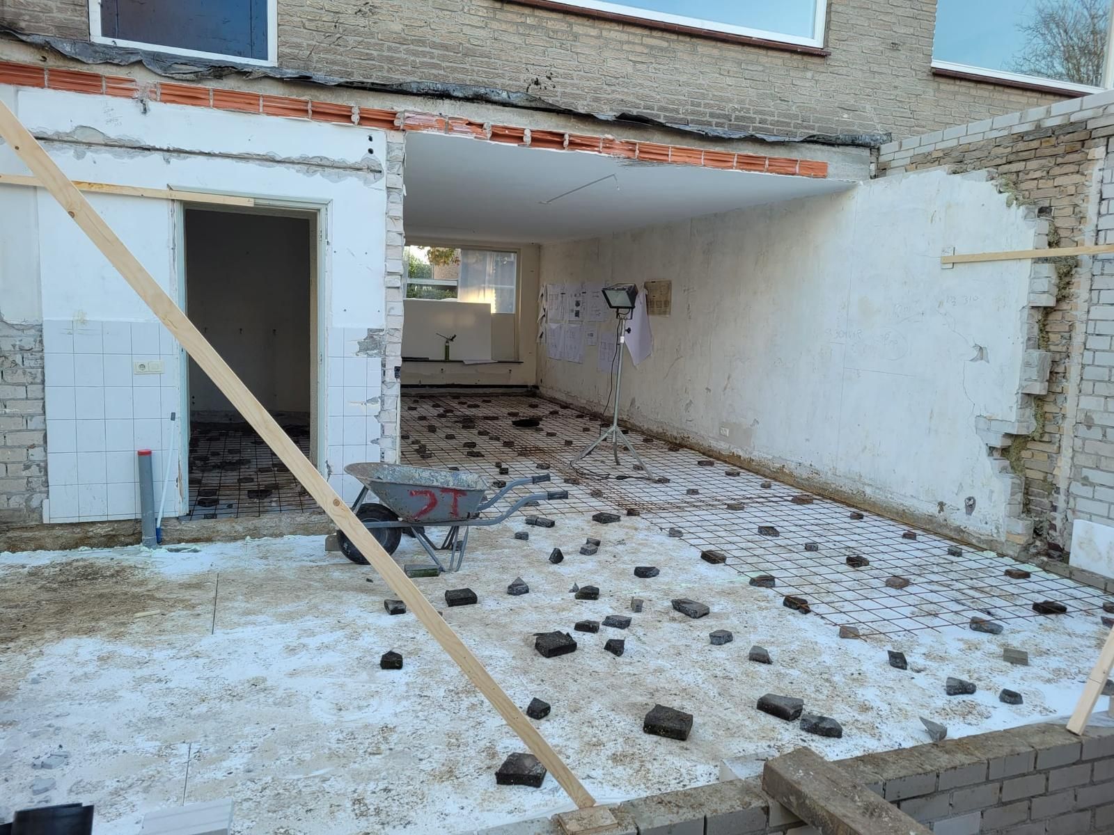 Een gebouw in aanbouw met een kruiwagen op de grond