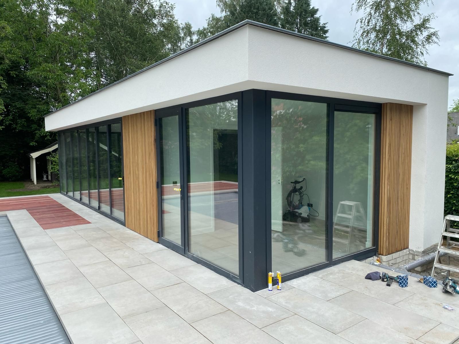 Een gebouw met veel ramen en een zwembad op de achtergrond.