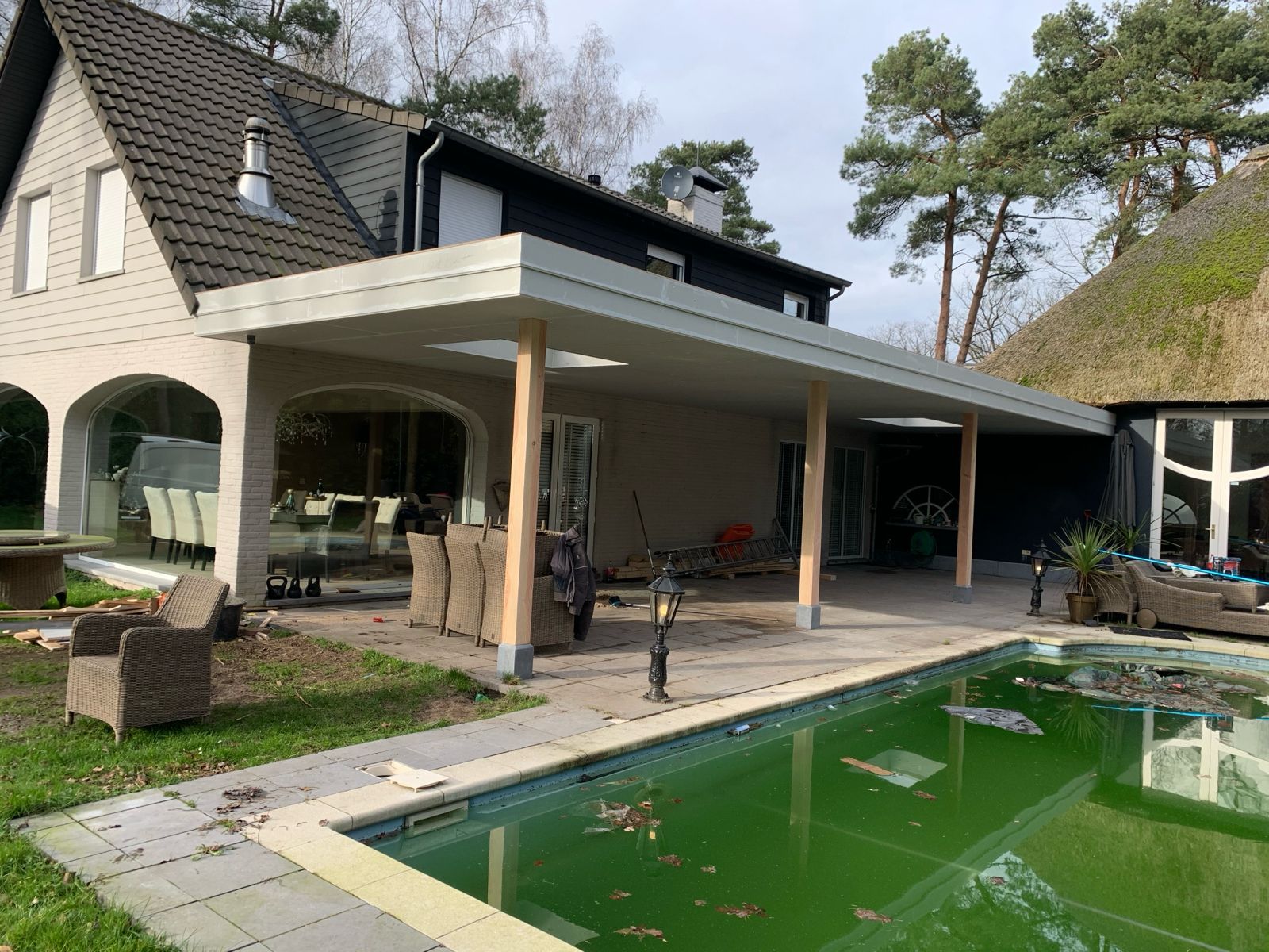 Een groot huis met een zwembad ervoor