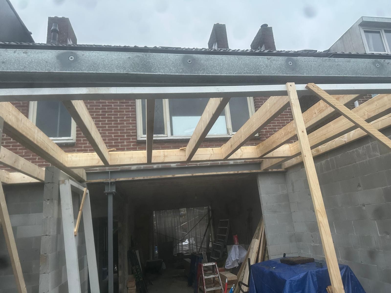 Er wordt een houten huis gebouwd met steigers en ladder.