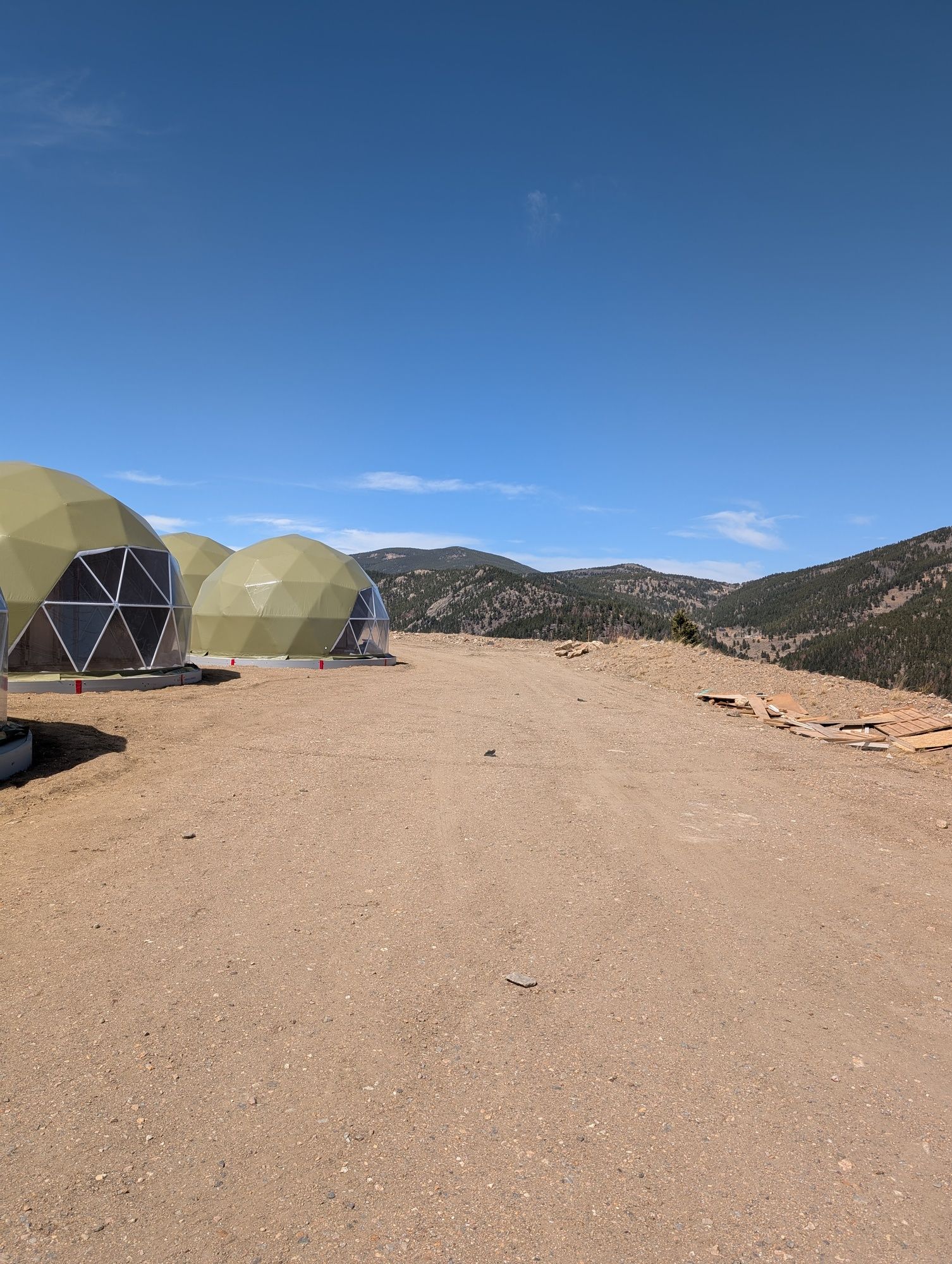 A group of tents are sitting on top of a dirt hill.