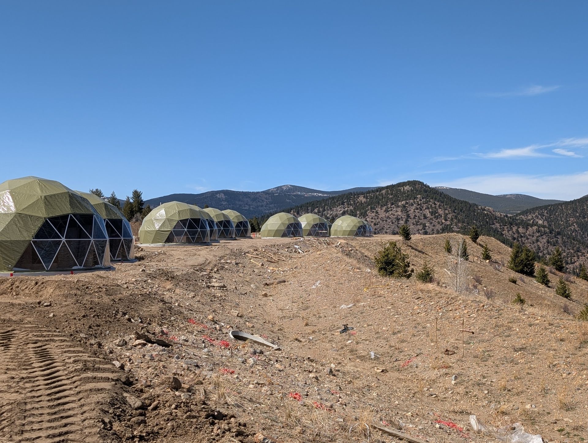 A group of tents are sitting on top of a dirt hill.