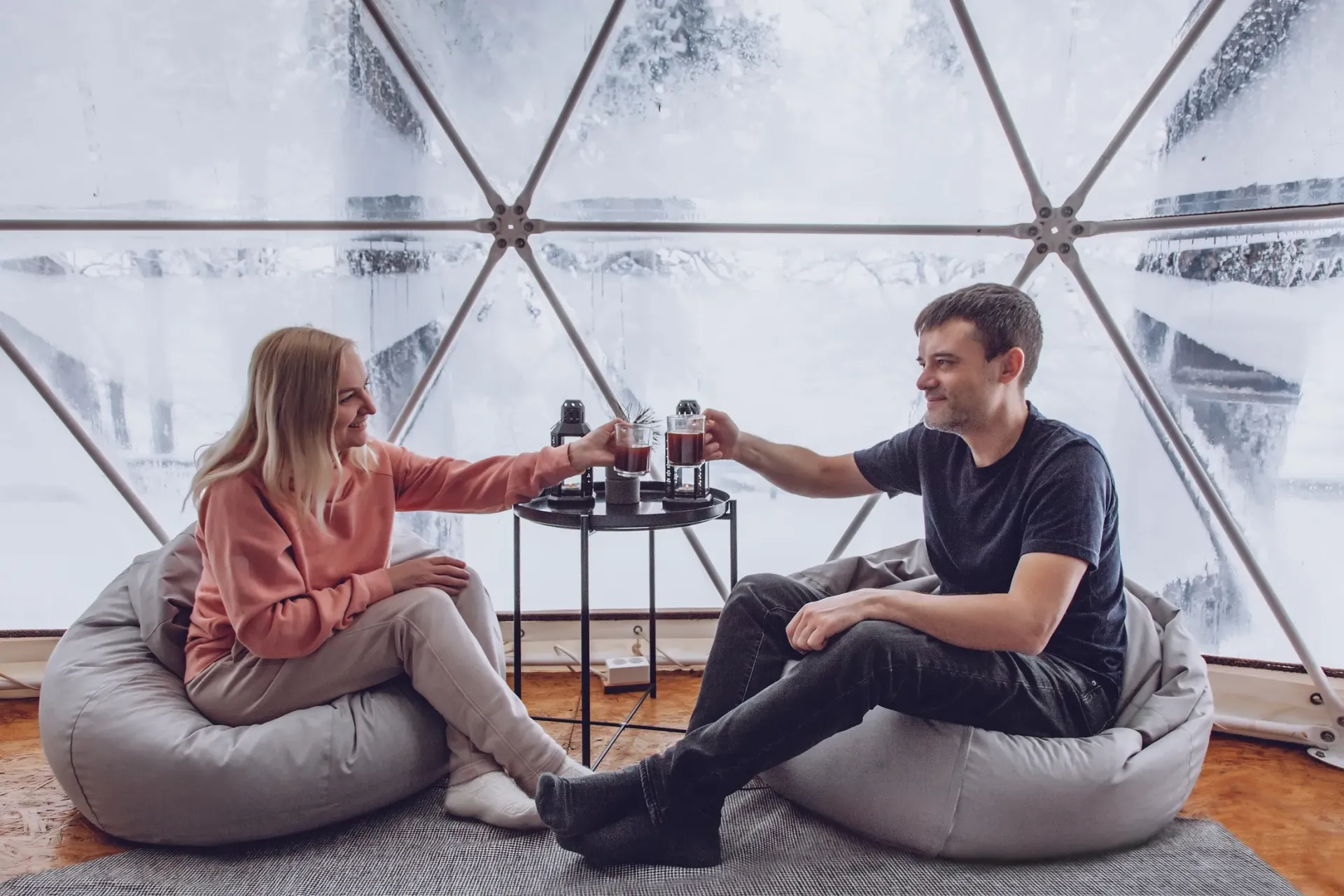 A man and a woman are sitting on bean bag chairs in a dome.