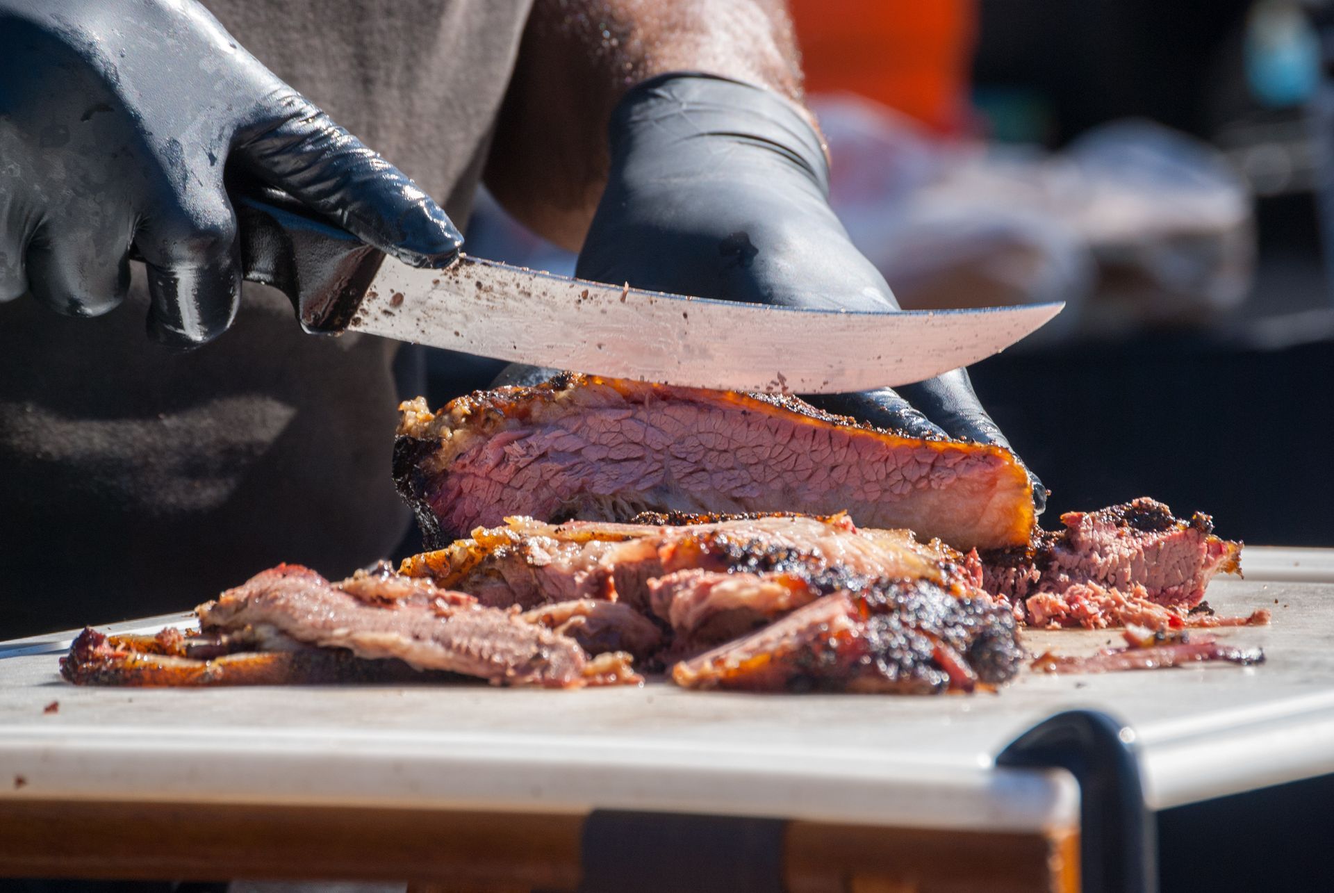 A person is cutting a piece of meat on a cutting board.