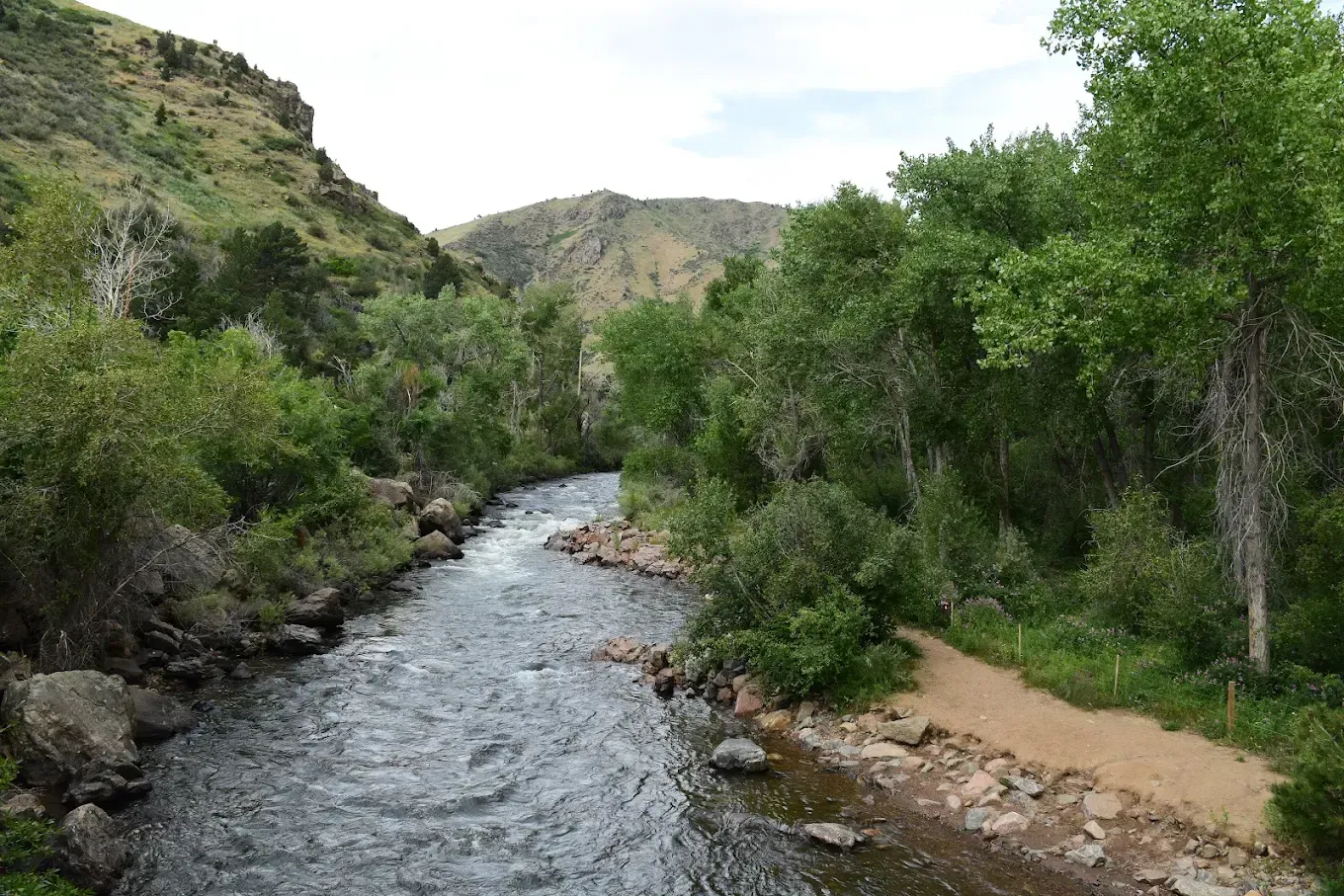 A river running through a valley surrounded by trees and rocks.