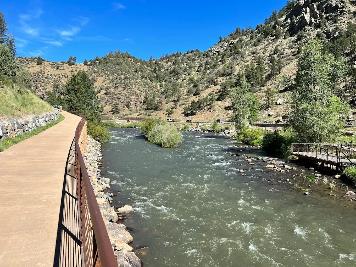 A river running through a valley with mountains in the background