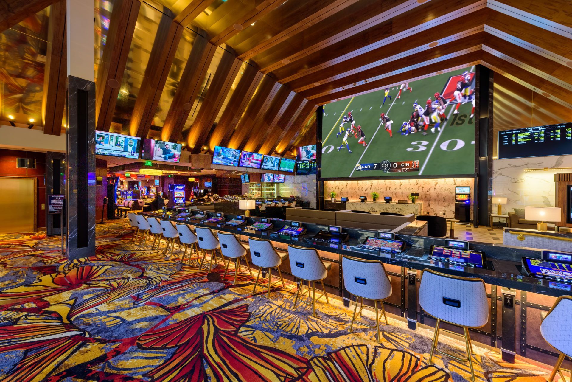 A large screen displays a football game in a casino.