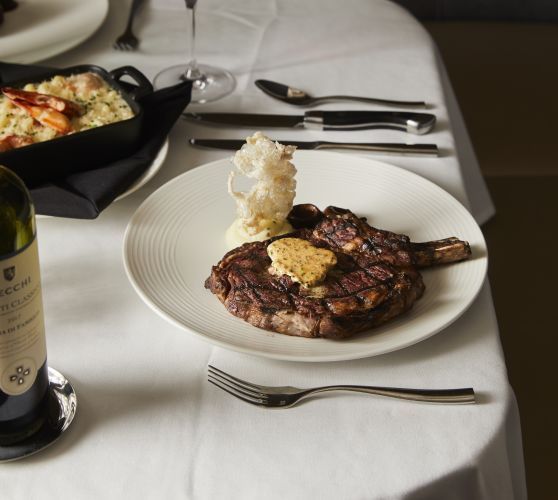 A bottle of wine sits next to a plate of food