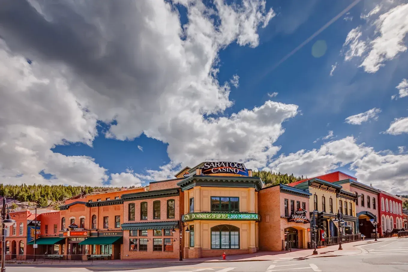A row of buildings on a city street with a cloudy sky in the background.