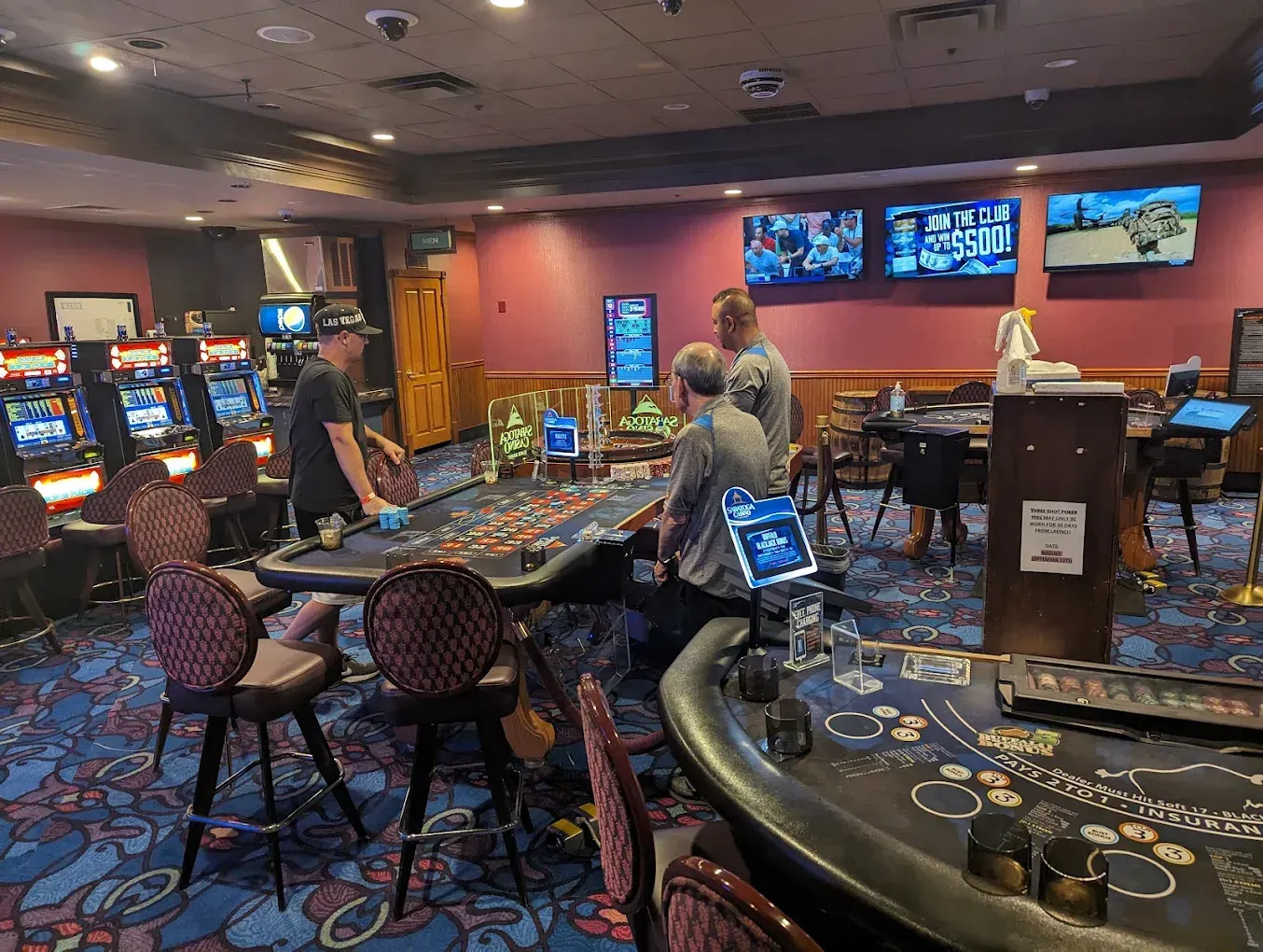 A group of people are playing roulette in a casino.