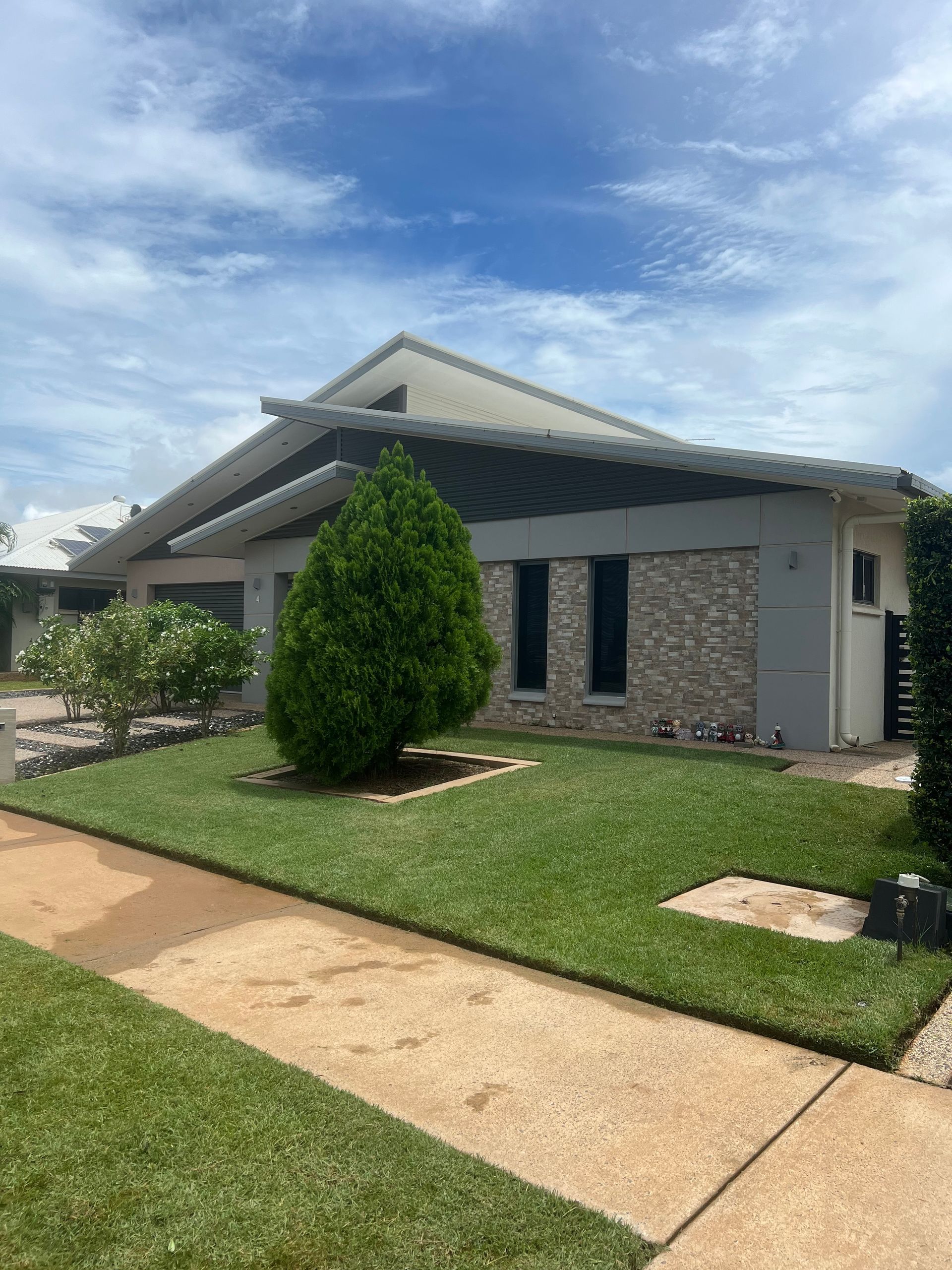 House with gray exterior, green lawn, sidewalk, and blue sky — Green Scene NT in Darwin, NT
