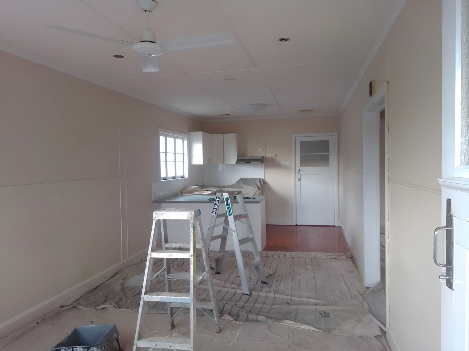 An Empty Kitchen With A Ladder In The Middle Of It — Kiwi Painter In Mooroobool, QLD