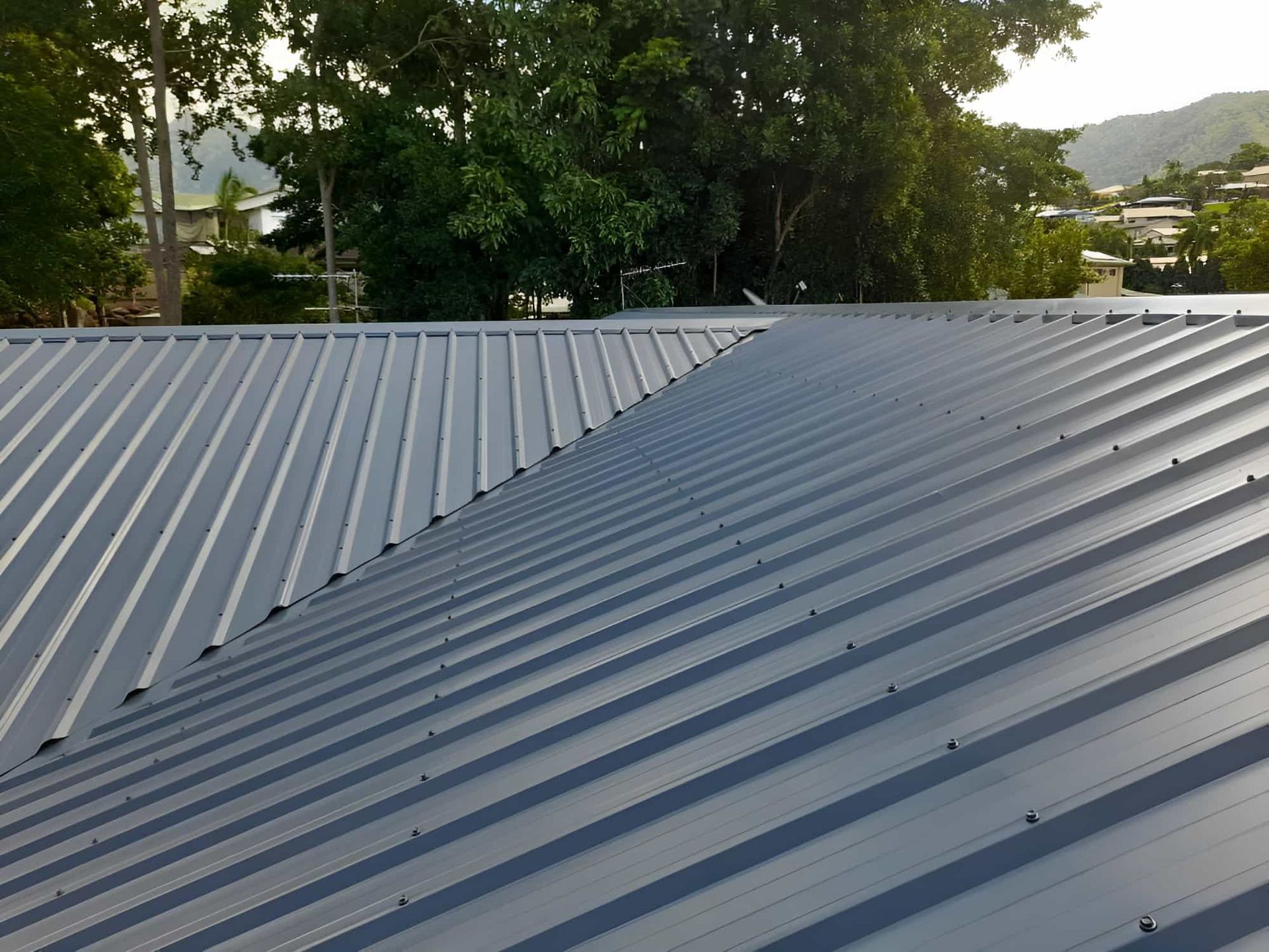 A Close Up Of A Roof With Trees In The Background — Kiwi Painter In Cairns, QLD