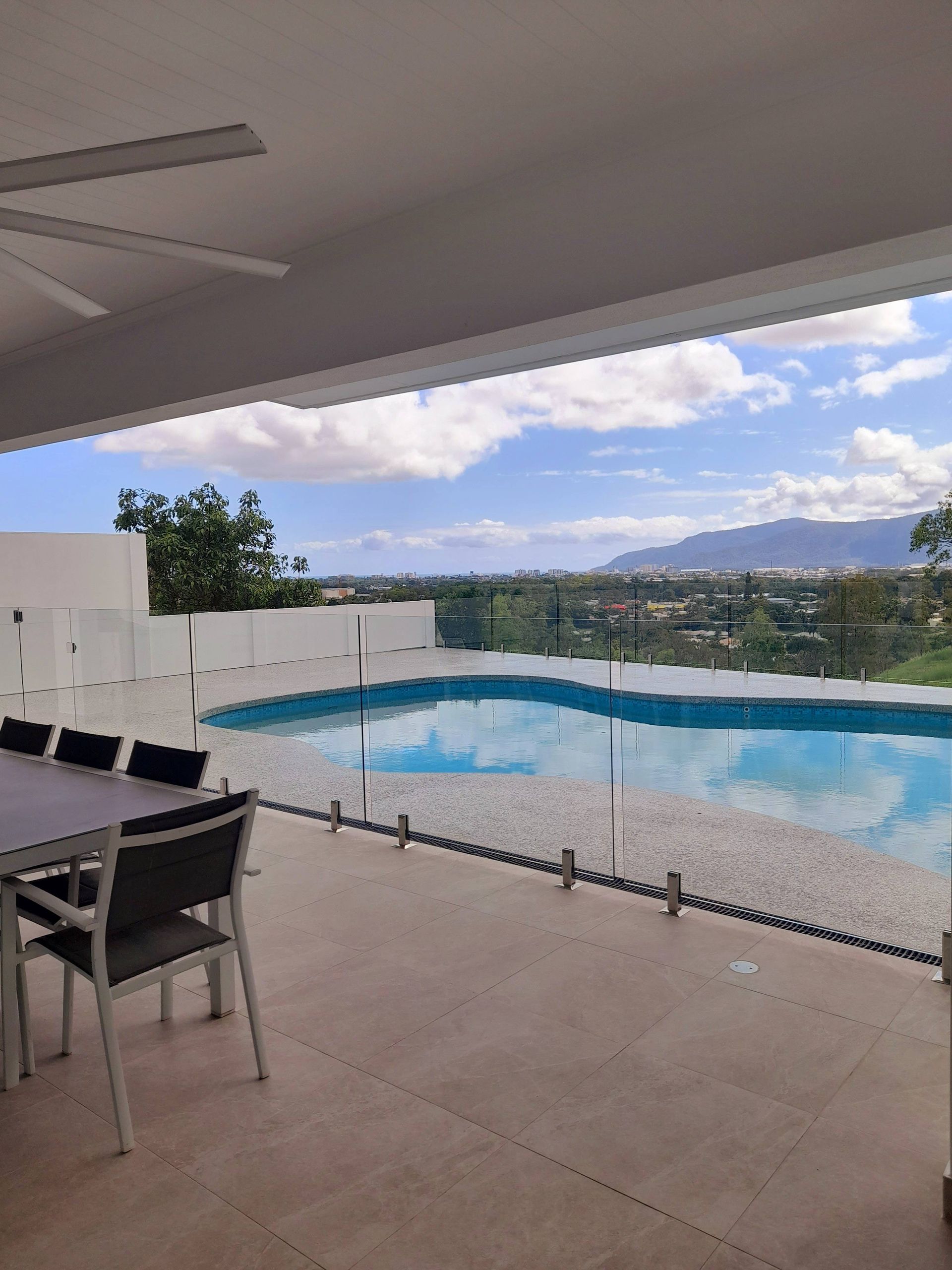 A white house with black windows and a blue sky in the background. — Kiwi Painter In Mooroobool, QLD