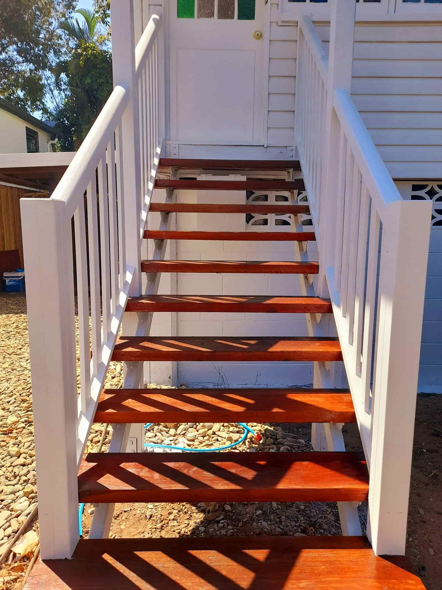 A set of wooden stairs leading up to a white house — Kiwi Painter In Mooroobool, QLD