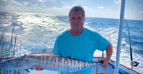 Man holding large fish on deep sea fishing charter Panama City Beach with Reel Groovy