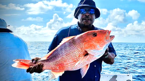 Man holding large red snapper on fishing charter Panama City Beach with Reel Groovy