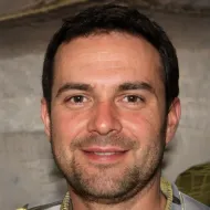 Un hombre con barba sonríe para la cámara.