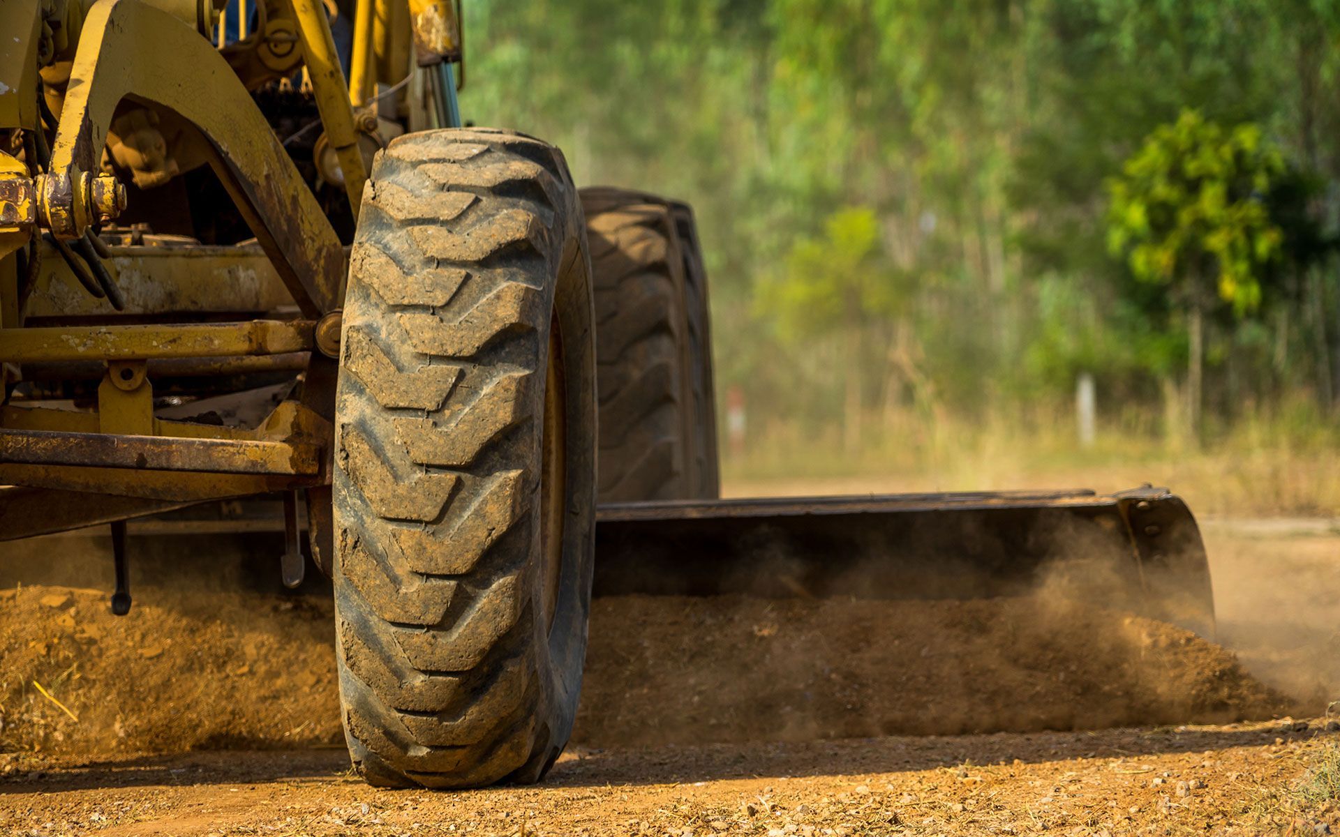 A bulldozer is moving dirt on a dirt road.