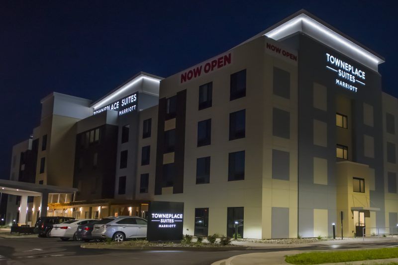 A large building with a sign that says `` now open '' is lit up at night.