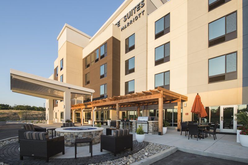 A large hotel with a patio area in front of it