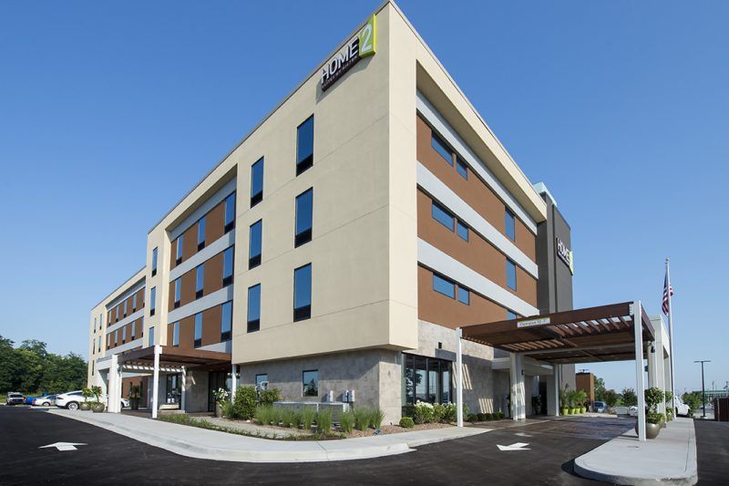 A large building with a lot of windows and a parking lot in front of it.