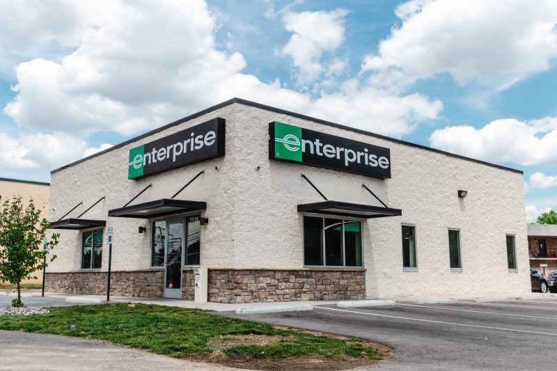 A white building with a green sign that says Enterprise.