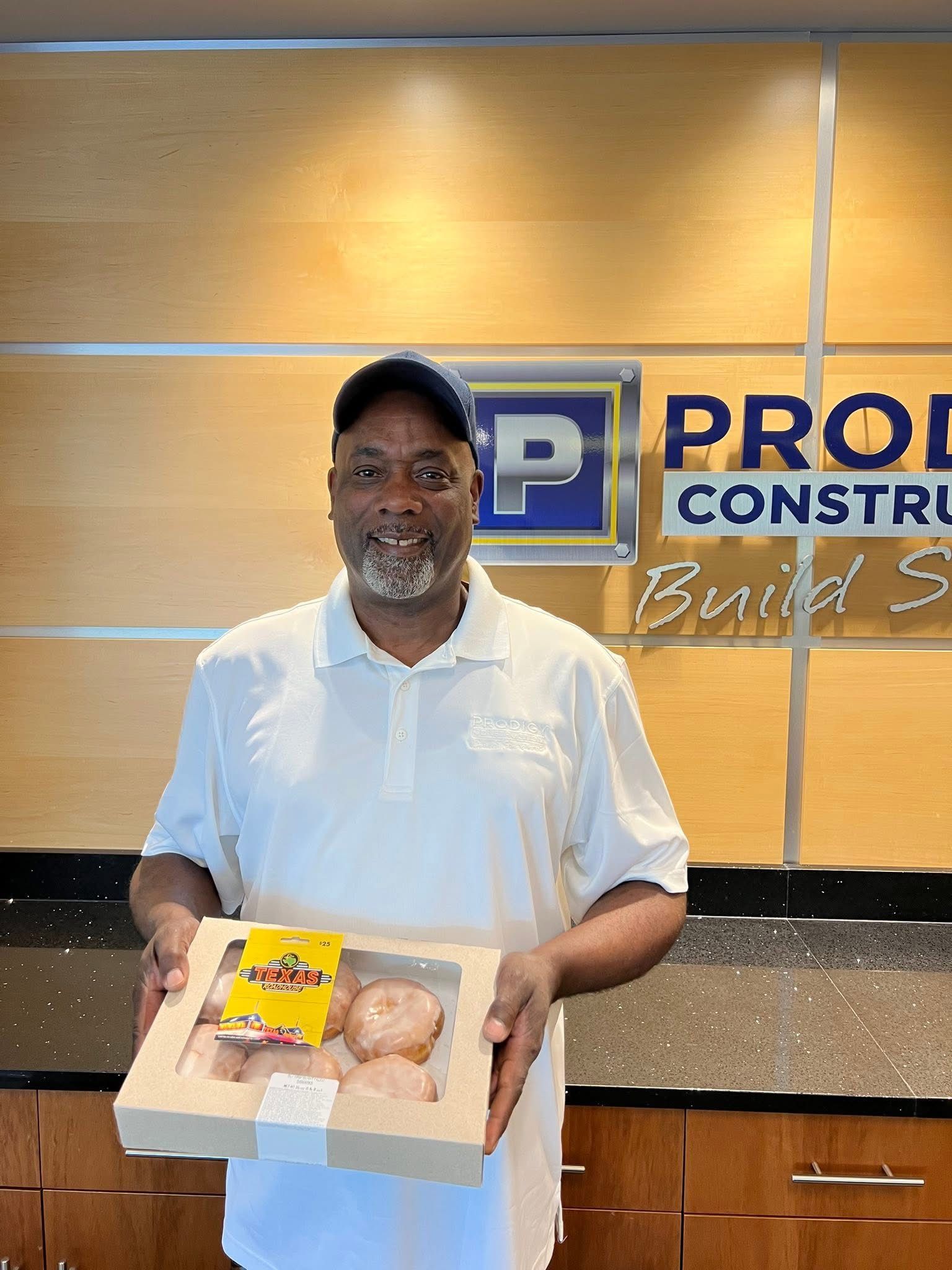 Derwin is holding a box of donuts.