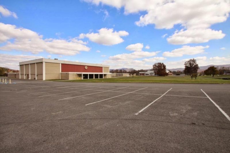 An empty parking lot with a large building in the background