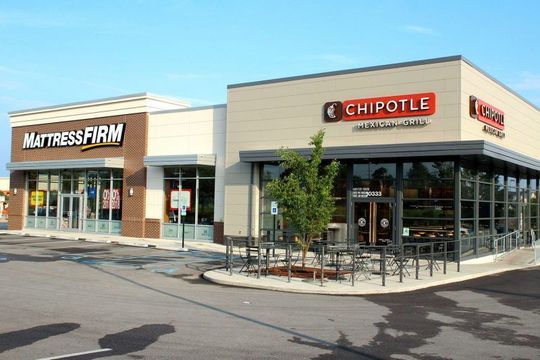 A chipotle restaurant is located next to a mattress firm store.