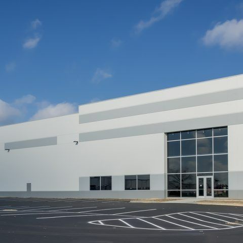 A large white building with a parking lot in front of it