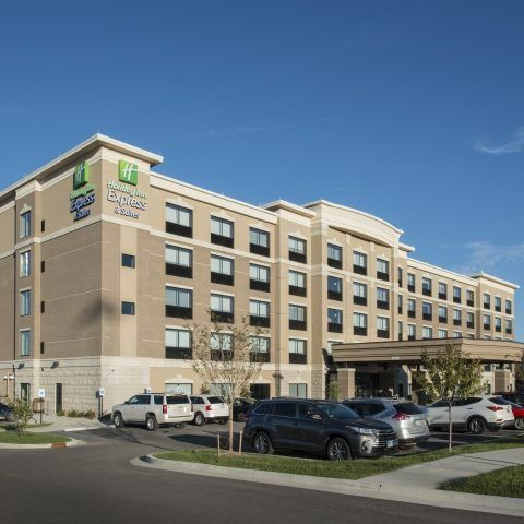 A large hotel with cars parked in front of it