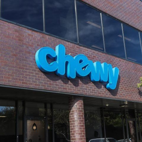 A blue chewy sign on a brick building