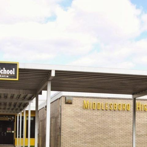 A brick school building with a yellow sign that says middleboro high school.