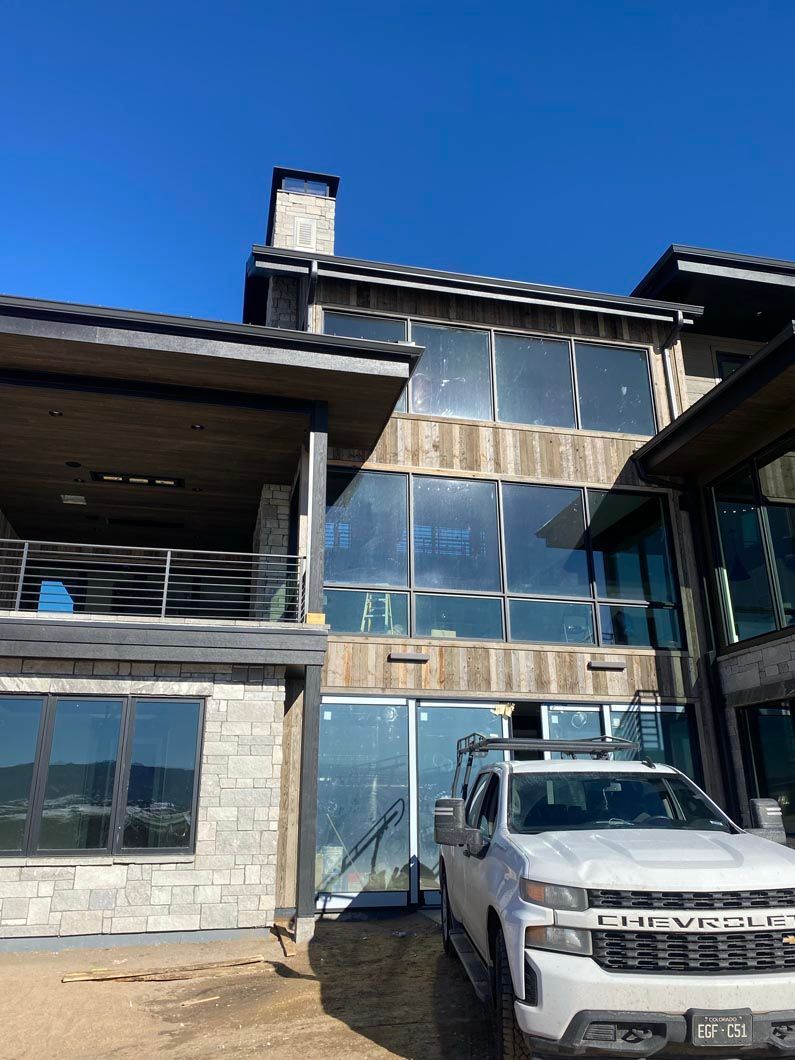 A white truck is parked in front of a large building.