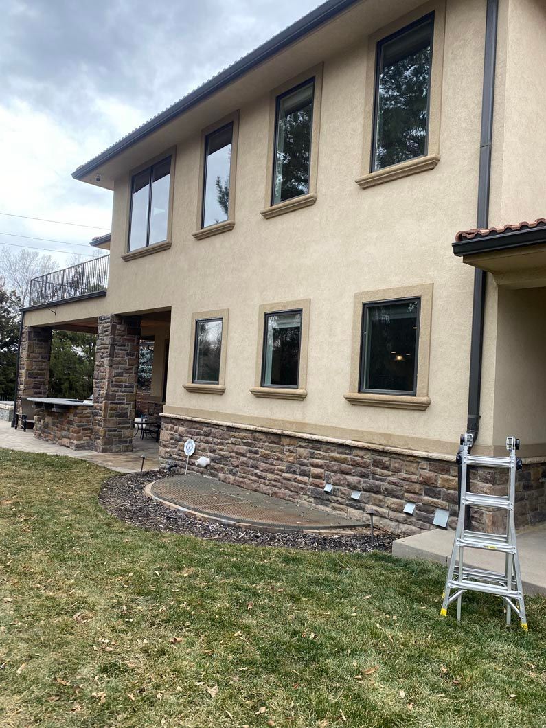 A large house with a lot of windows and a ladder in front of it.