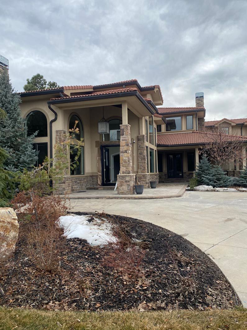 A large house with a lot of windows and a driveway in front of it.
