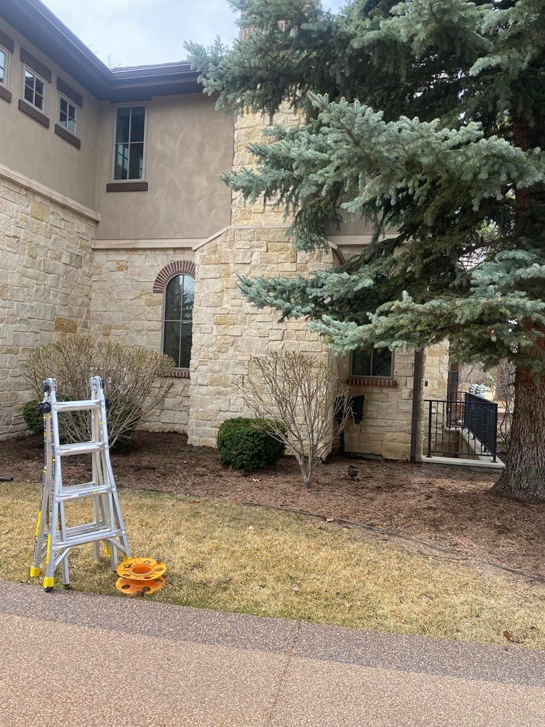 A ladder is sitting in front of a large stone building.