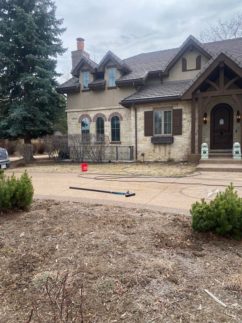 A large house with a lot of windows is sitting on top of a dirt field.