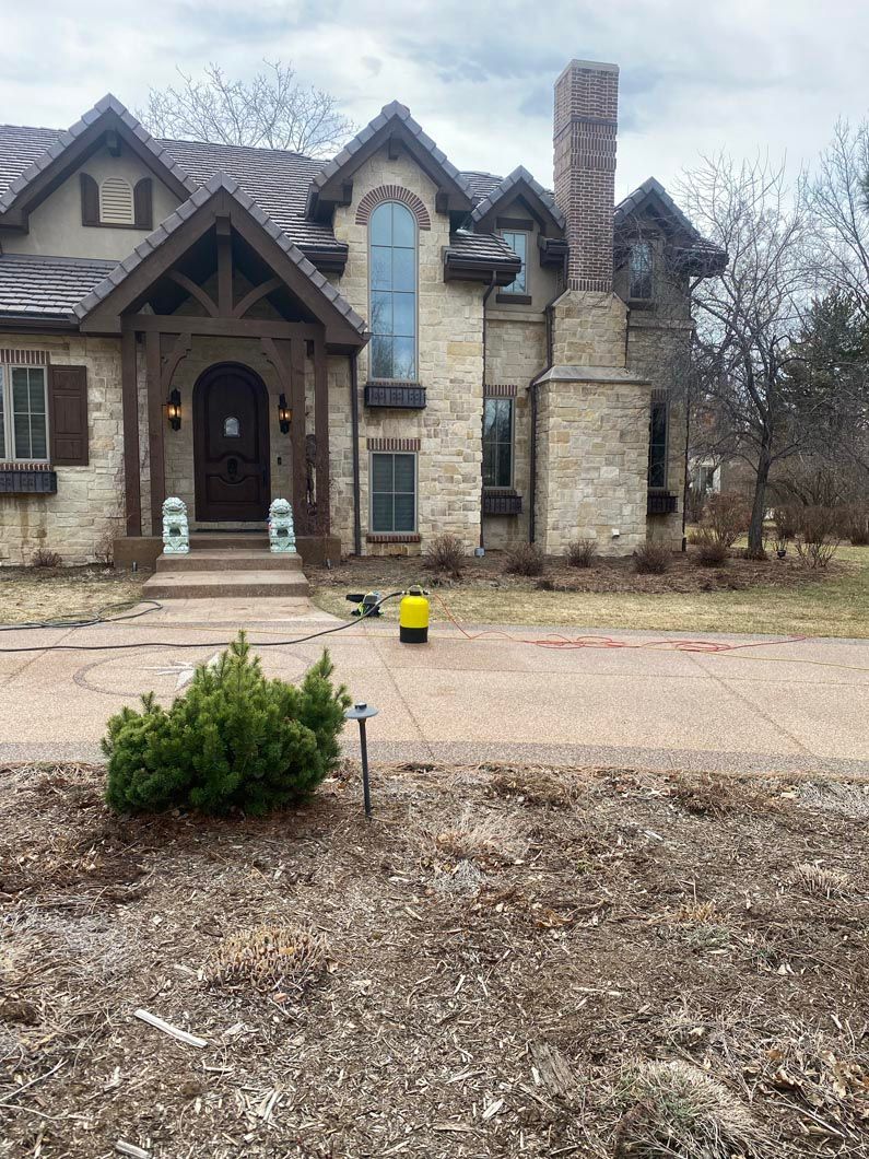 A large house with a lot of windows is sitting on top of a dirt field.