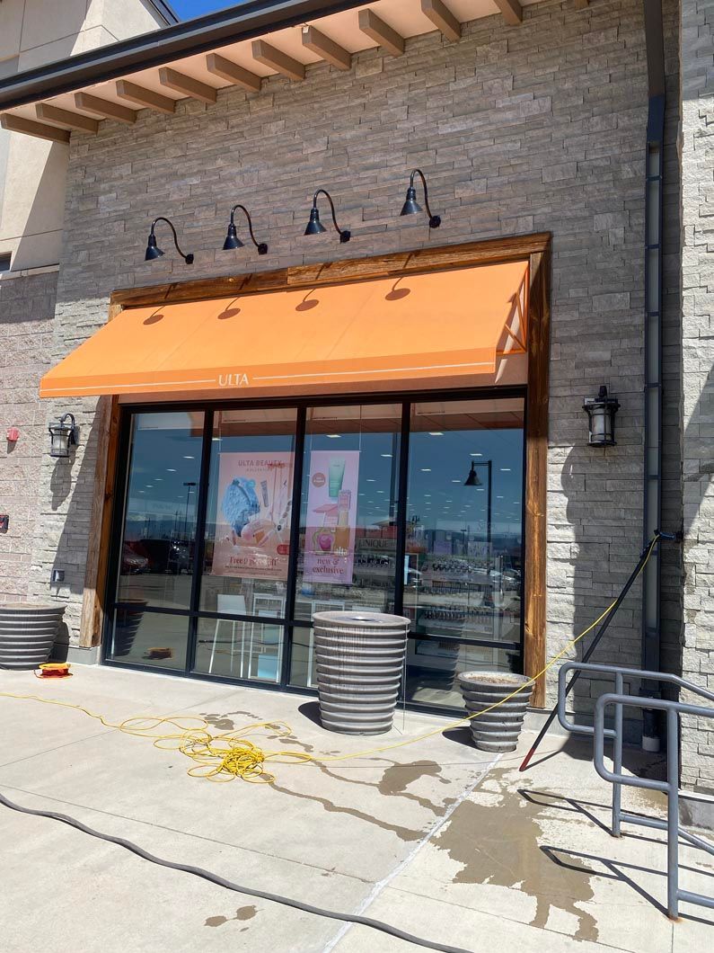 A store front with an orange awning over the windows.